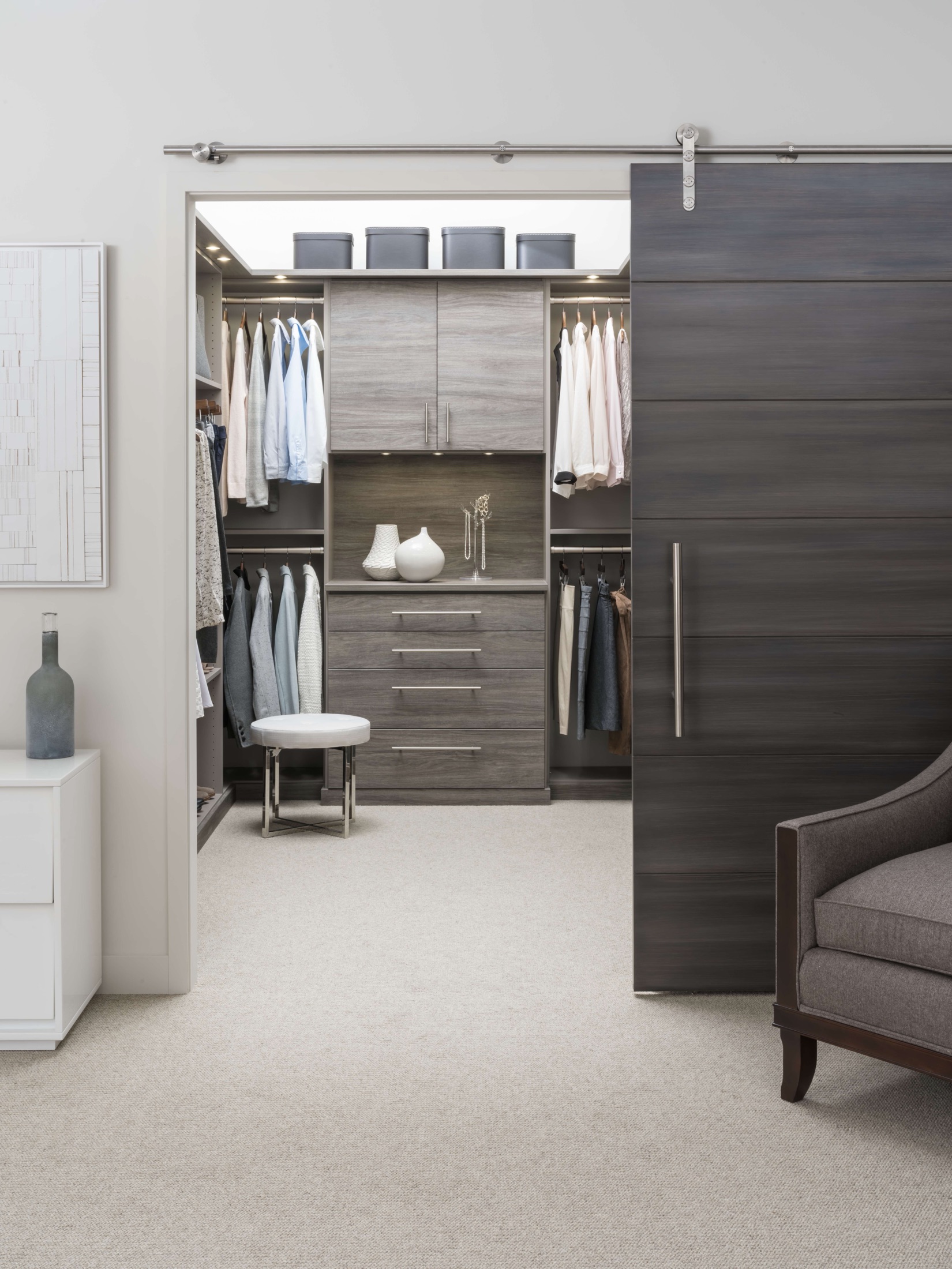 Grey wood-grain closet finish with sliding barn door and soft-close drawers in a Delaware home
